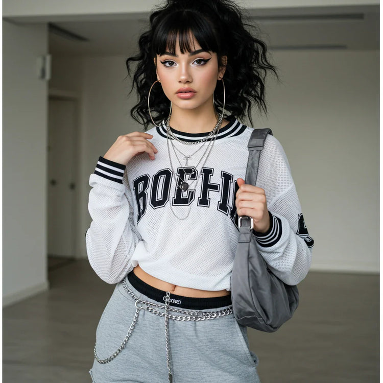 Are you looking for a trendy oversized women’s sweatshirt? A stylish teenager strikes a bold, confident pose in a white and gray varsity-style sweatshirt, perfect for streetwear, casual fashion, and layering.